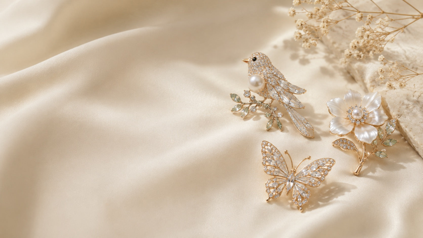A crystal bird, butterfly and mother-of-pearl flower brooch on cream silk